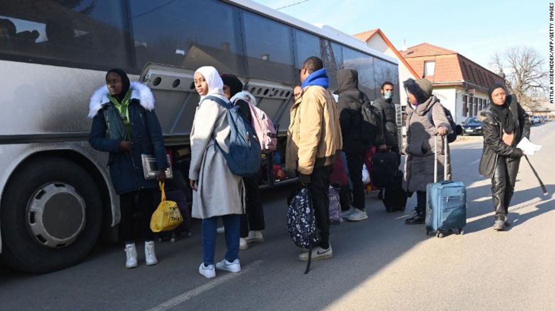 Estudiantes universitarios, incluidos muchos de Nigeria, que huyen de la capital ucraniana, Kyiv, guardan su equipaje mientras suben a un autobús cerca de la frontera húngaro-ucraniana en el pueblo de Tarpa en Hungría el 28 de febrero de 2022.