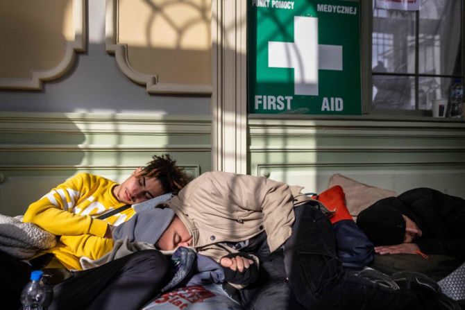 Refugiados de Ucrania descansan en un punto de recepción temporal organizado en la estación principal de trenes de Przemysl, en el este de Polonia, el 28 de febrero de 2022.