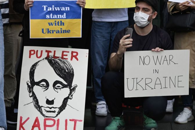 Una persona sostiene una pancarta en la que se compara a Putin con Hitler fuera de la oficina del representante de Rusia en Taipei, el 1 de marzo de 2022.