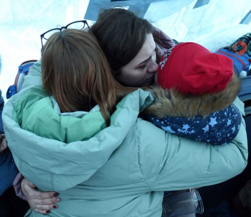 Un grupo de mujeres se abrazan dentro de una carpa instalada cerca de la estación principal de trenes de Lviv en el oeste de Ucrania el 28 de febrero de 2022.