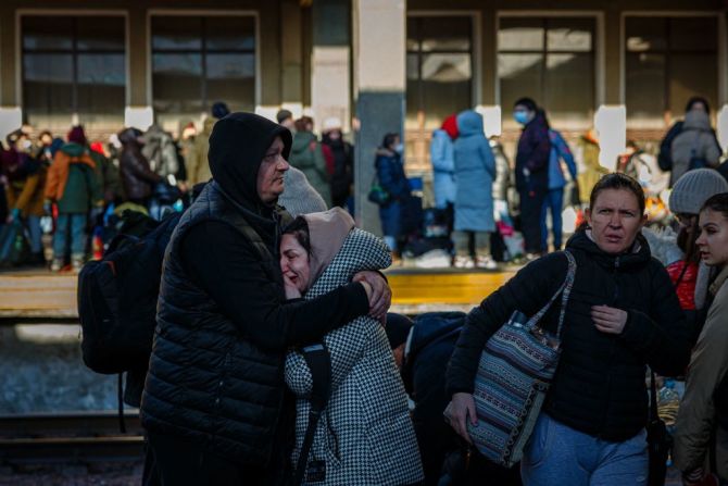 Un hombre abraza a su esposa antes de que ella aborde un tren de evacuación en la estación central de trenes de Kyiv el 28 de febrero de 2022.