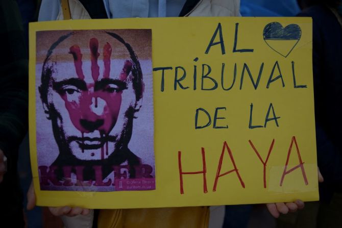 Una mujer sostiene un cartel que muestra la cara de Putin y pide que sea condenado en el Tribunal de La Haya. La protesta se realizó en la Plaza La Marina, en Málaga, España, el 28 de febrero de 2022.