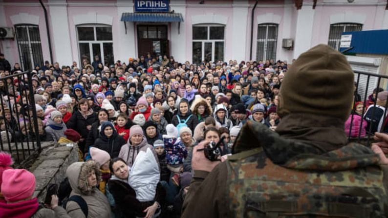 Un miembro del ejército ucraniano da instrucciones a mujeres y niños que suben a un tren de evacuación en Irpin, Ucrania. Imágenes de Chris McGrath/Getty