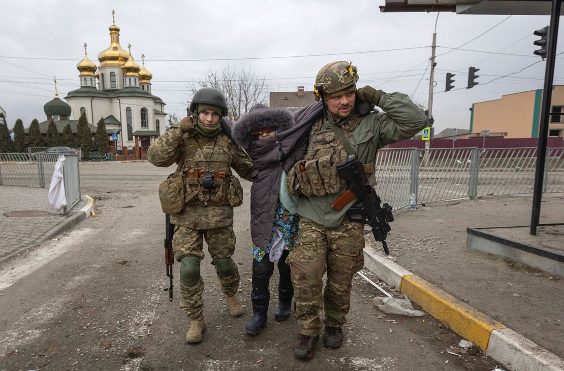 Militares ucranianos ayudan a una mujer en la ciudad de Irpin, Ucrania, el 6 de marzo.