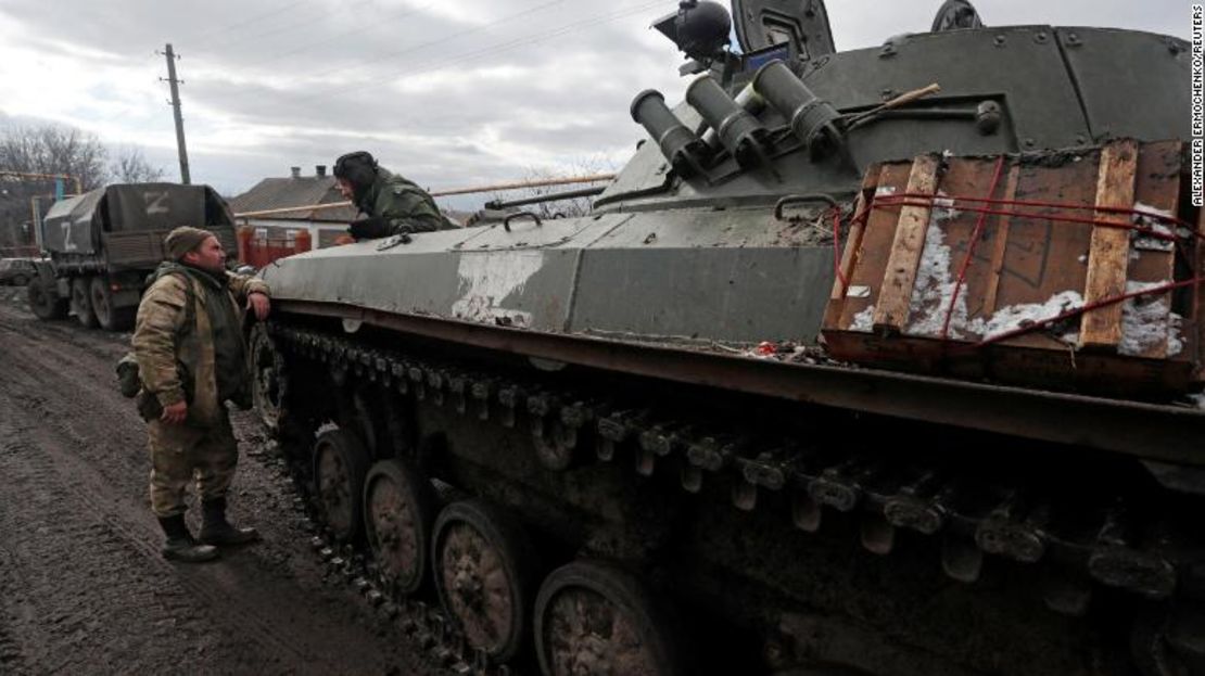 Soldados con uniformes sin insignias se ven junto a un vehículo blindado con el símbolo "Z" pintado en un costado, en la aldea de Bugas, controlada por los separatistas, en la región de Donetsk en Ucrania.