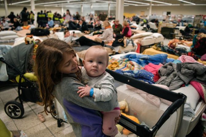 Una niña juega con un bebé en un refugio temporal que acoge a los refugiados ucranianos situado en un antiguo centro comercial cerca de la ciudad de Przemysl, el 08 de marzo de 2022. - Más de dos millones de personas han huido de Ucrania desde que Rusia lanzó su invasión a gran escala hace menos de dos semanas, dijo la ONU el 08 de marzo de 2022.