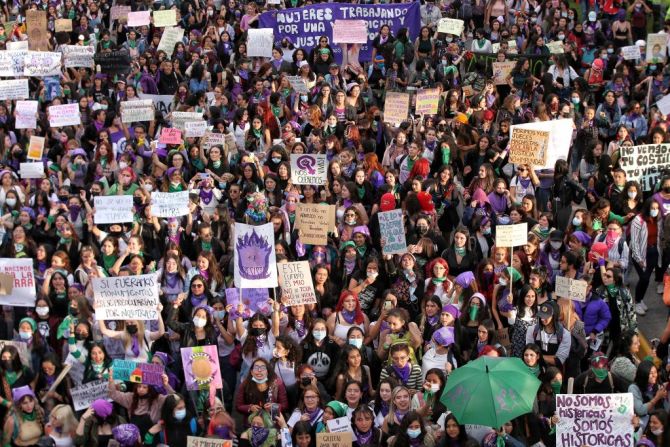 Mujeres vestidas de negro y morado participan en la manifestación para conmemorar el Día Internacional de la Mujer en Bogotá, el 8 de marzo de 2022.