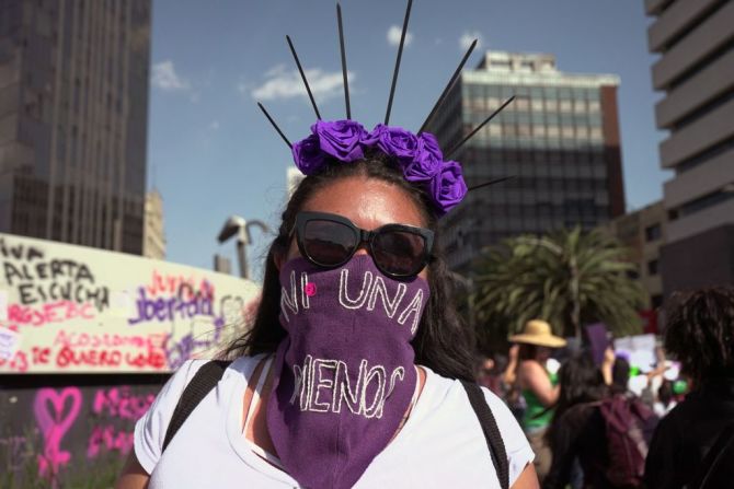 Una mujer cubre su cara con un pañuelo morado que dice "Ni una menos" durante la marcha del 8M en la Ciudad de México, el 8 de marzo de 2022.