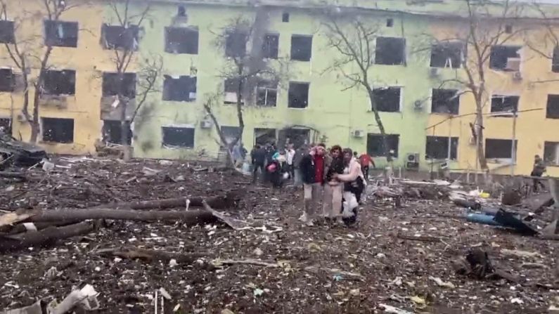 Personas son asistidas mientras salen de un edificio en la zona del bombardeo a un hospital.