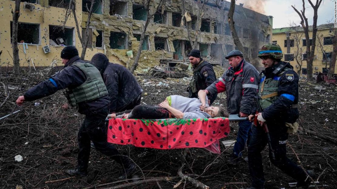 Empleados y voluntarios de emergencias ucranianos llevan a una mujer embarazada herida desde el hospital de maternidad y niños que fue dañado por los bombardeos en Mariupol, Ucrania, el miércoles 9 de marzo de 2022.