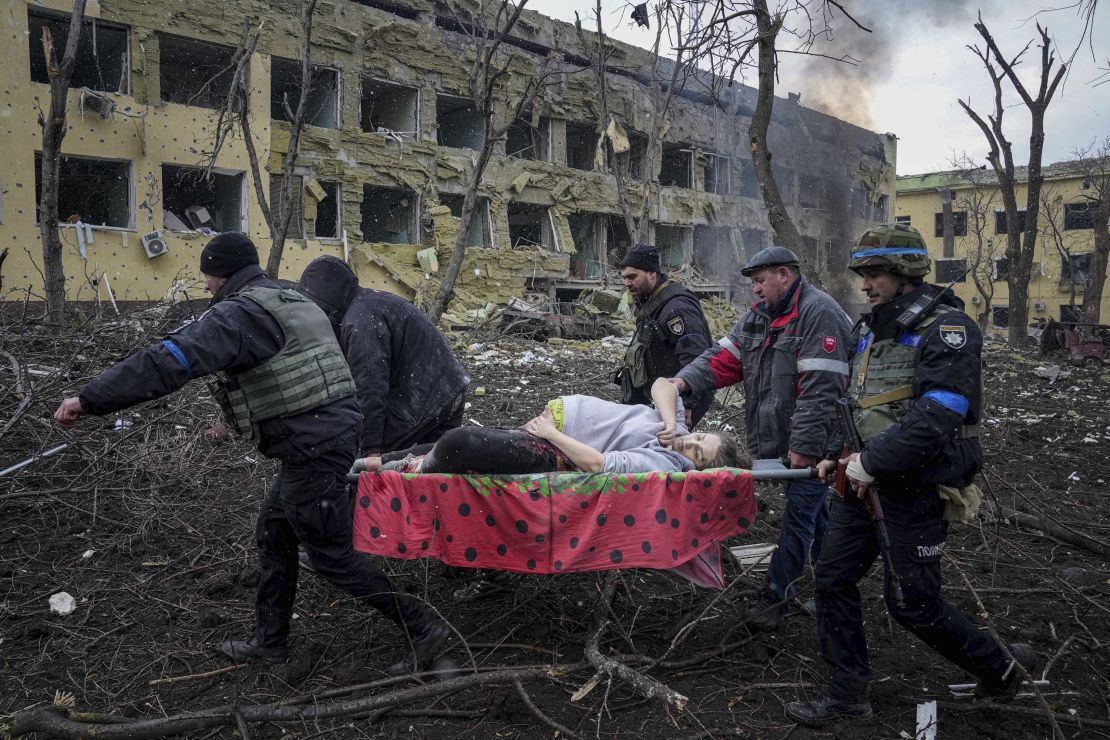 Empleados y voluntarios de emergencias ucranianos llevan a una mujer embarazada herida desde un hospital de maternidad que fue dañado por un bombardeo en Mariupol, Ucrania, el miércoles 9 de marzo de 2022.