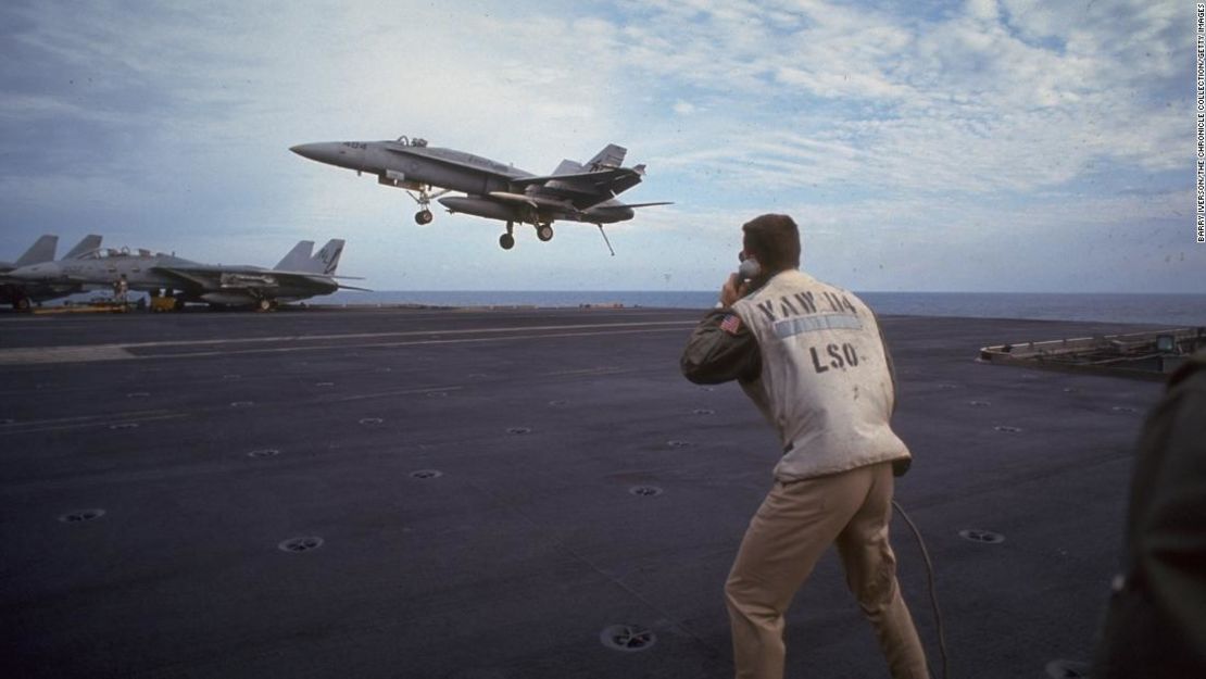La tripulación observa el aterrizaje de un avión de combate en el USS Kitty Hawk, durante un ataque aéreo aliado liderado por Estados Unidos contra Iraq, reforzando las resoluciones de la ONU posteriores a la Guerra del Golfo, el 19 de enero de 1993.