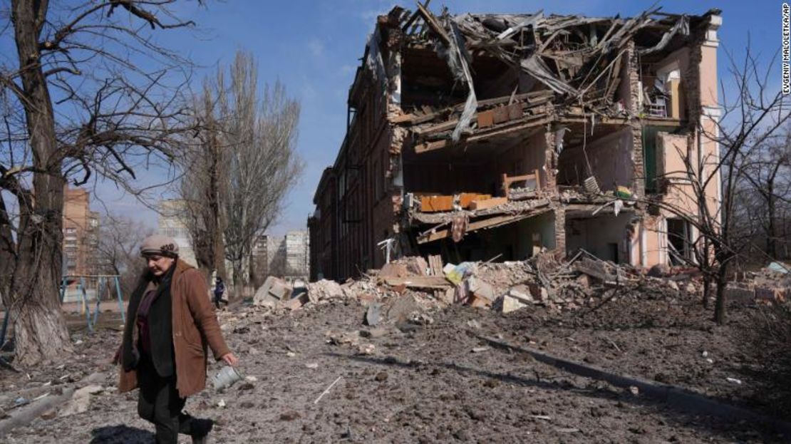 Una mujer camina junto a un edificio dañado por los bombardeos en Mariupol el domingo.