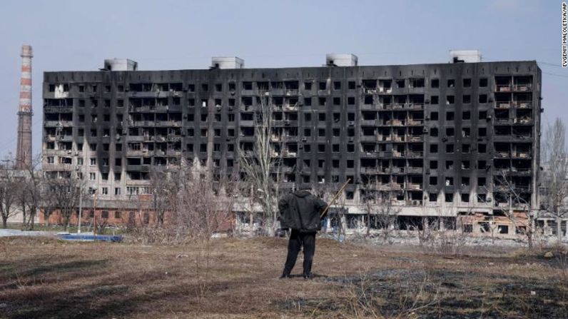 Un hombre observa un edificio habitacional quemado que resultó dañado por los bombardeos en Mariúpol el 13 de marzo.