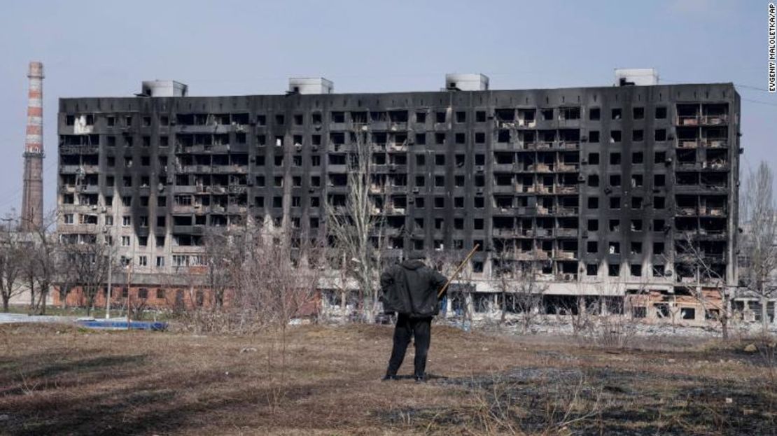 Un hombre observa un edificio habitacional quemado que resultó dañado por los bombardeos del domingo en Mariupol.