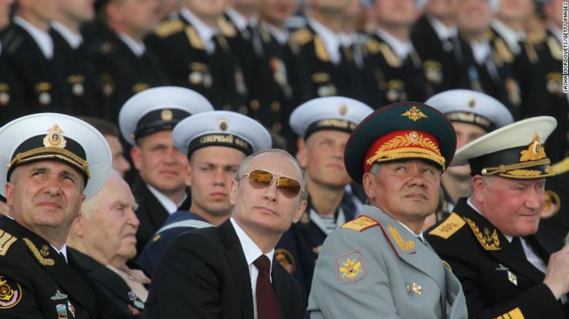 El presidente de Rusia Vladimir Putin, en el centro, y el ministro de Defensa Sergei Shoigu, a la derecha, observan el desfile militar del Día de la Marina el 27 de julio de 2014, en la base naval de Severomorsk, Rusia.