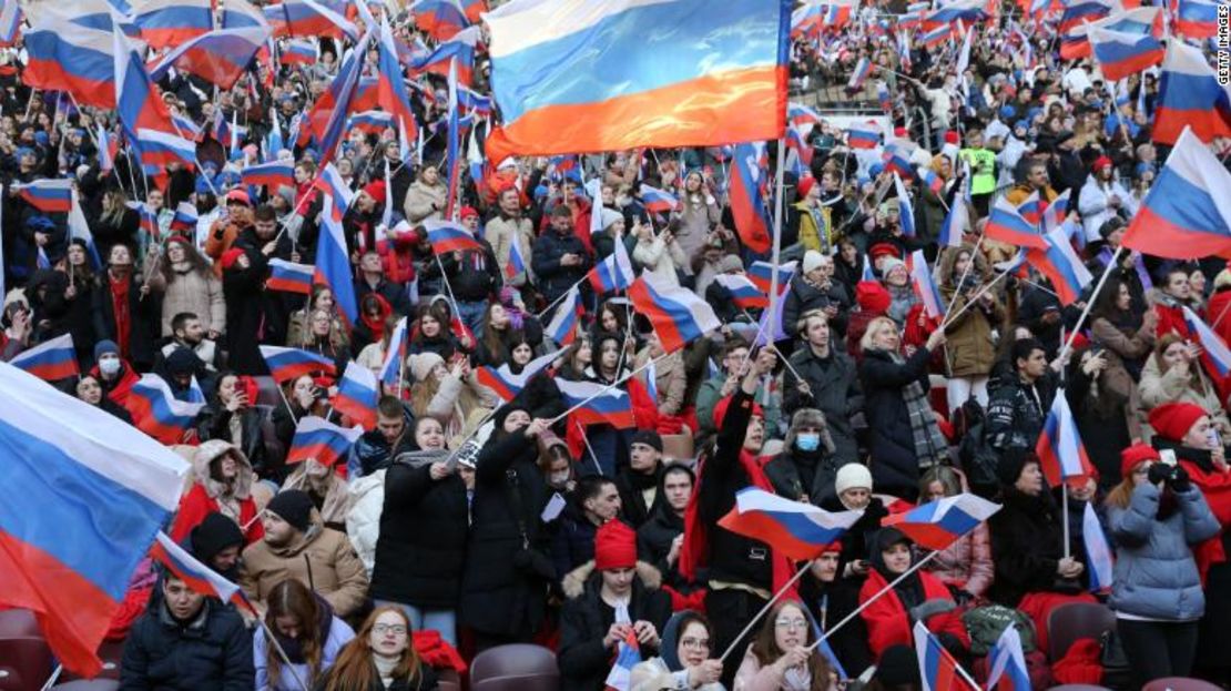 Los rusos sostienen banderas y animan durante el concierto que contó con música en vivo y discursos de destacados partidarios de Putin.