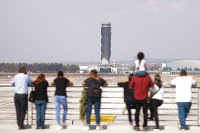 Personas observan la torre de control de la nueva terminal aérea.