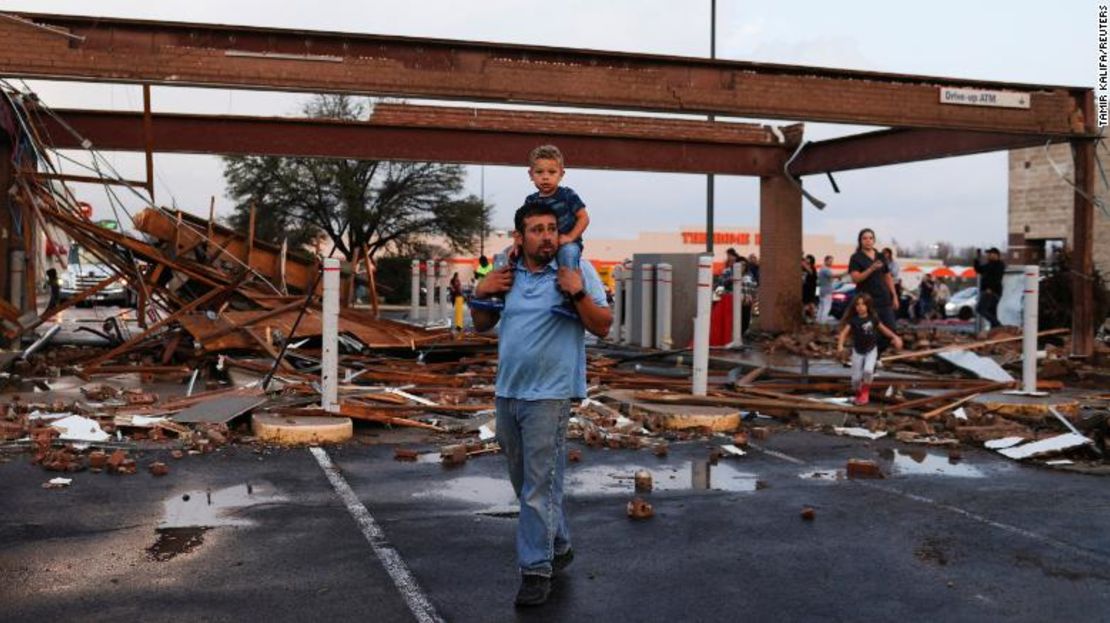 Arturo Ortega y su hijo Kaysen Ortega, de 2 años, inspeccionan los daños en un centro comercial el lunes después de que un posible tornado azotara Round Rock, Texas.