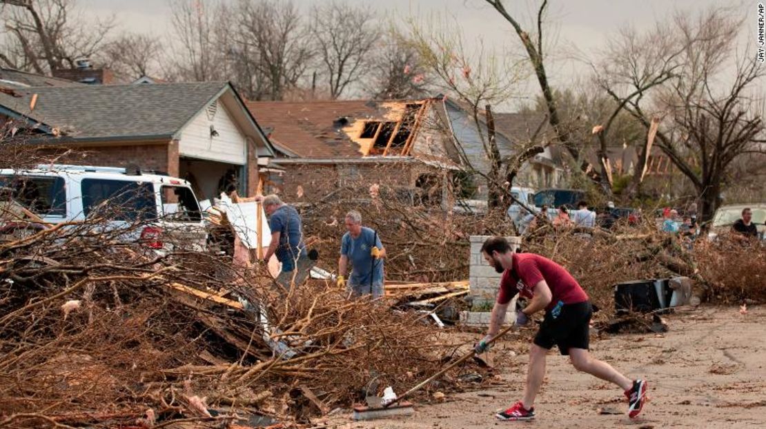 Jarrod Schneider, quien vive en Round Rock, Texas, ayuda a sus vecinos a limpiar los escombros este lunes, después de que un posible tornado dejará varias casas fuertemente dañadas.