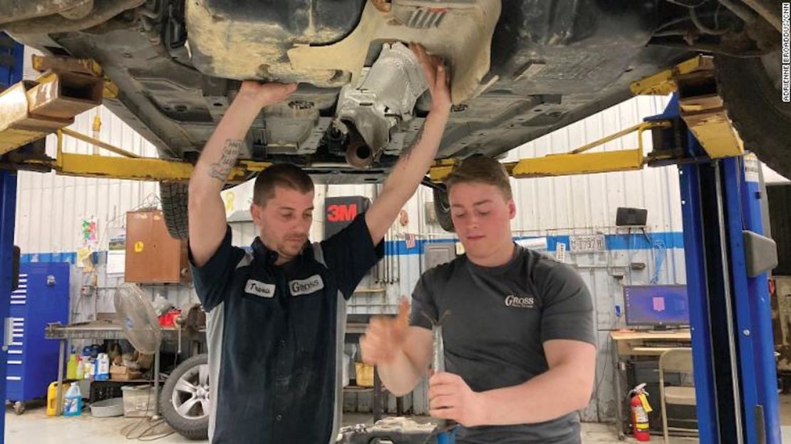 Travis Lewis, a la izquierda, comienza a reemplazar el tanque de gasolina dañado en Gross Auto Group en Neillsville, Wisconsin.