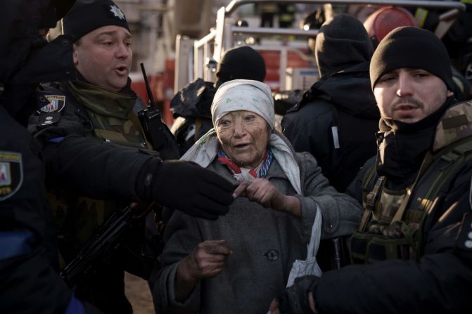 Policías ayudan a una anciana después de ser rescatada de un apartamento que fue atacado por bombardeos en Kyiv el 15 de marzo.