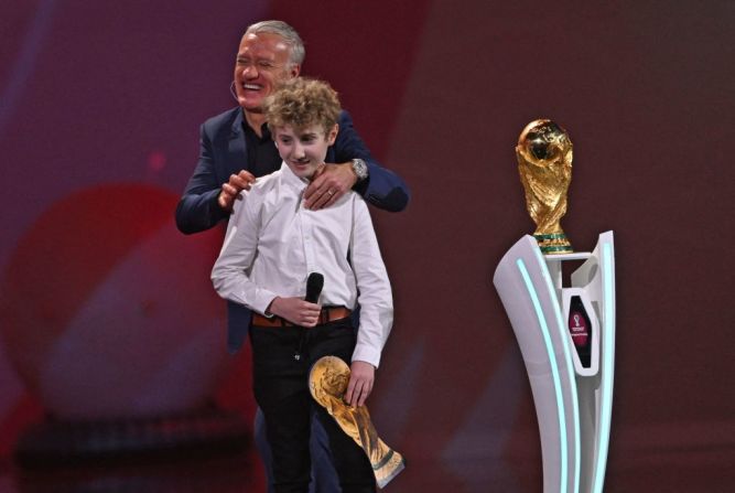 El entrenador de Francia Didier Deschamps (detrás) aparece en el escenario junto al trofeo de la Copa del Mundo y con Joris, un niño francés (al frente) cuya emocionalidad se volvió viral en la final de la Copa Mundo 2018.