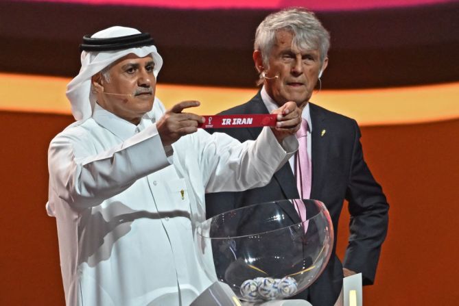 El exfutbolista qatarí Adel Ahmed MalAllah sostiene la tarjeta con el nombre de Irán durante el sorteo de la Copa del Mundo de 2022 en Qatar.