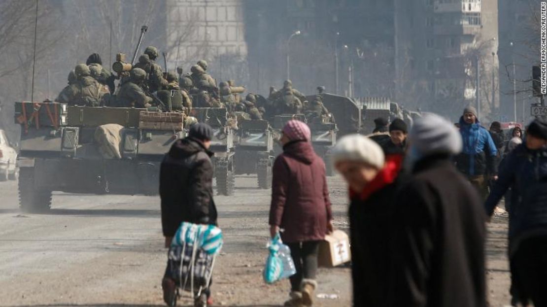 Miembros del servicio de las tropas prorrusas conducen vehículos blindados frente a los residentes locales durante el conflicto entre Ucrania y Rusia en la sitiada ciudad portuaria del sur de Mariúpol, Ucrania 24 de marzo de 2022.