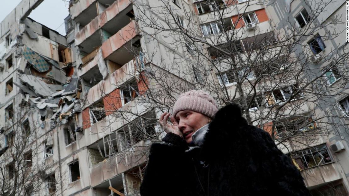 Una mujer ucraniana cerca de un bloque de edificios de apartamentos destruidos en la ciudad portuaria sitiada de Mariúpol el 17 de marzo de 2022.