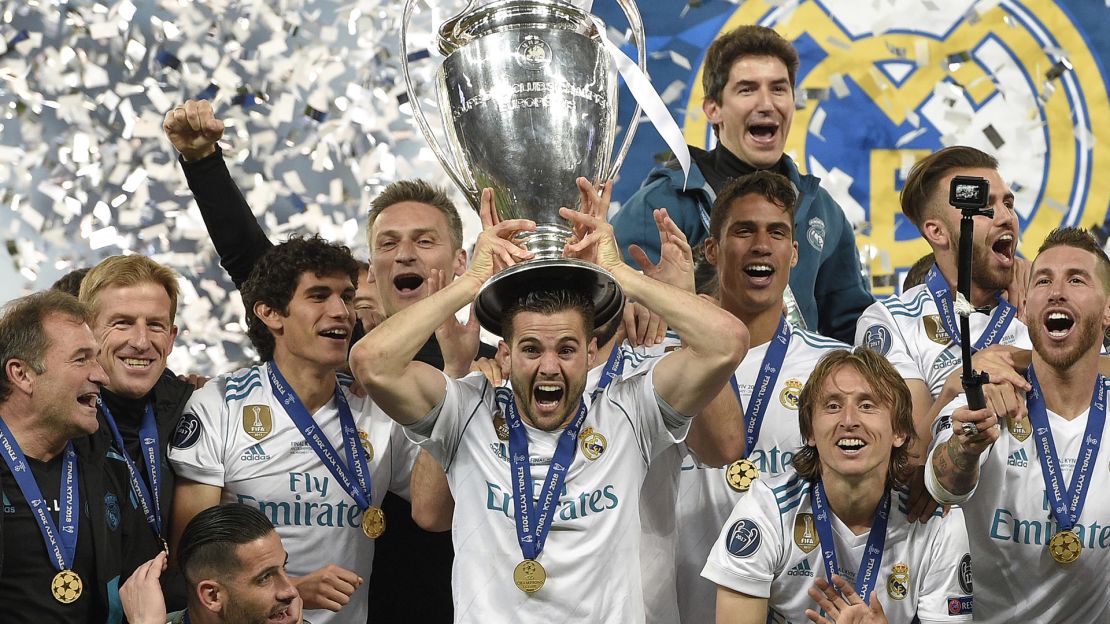 Real Madrid's Spanish defender Nacho Fernandez (C) lifts the trophy after winning the UEFA Champions League final football match between Liverpool and Real Madrid at the Olympic Stadium in Kiev, Ukraine on May 26, 2018. - Real Madrid defeated Liverpool 3-1. (Photo by LLUIS GENE / AFP)