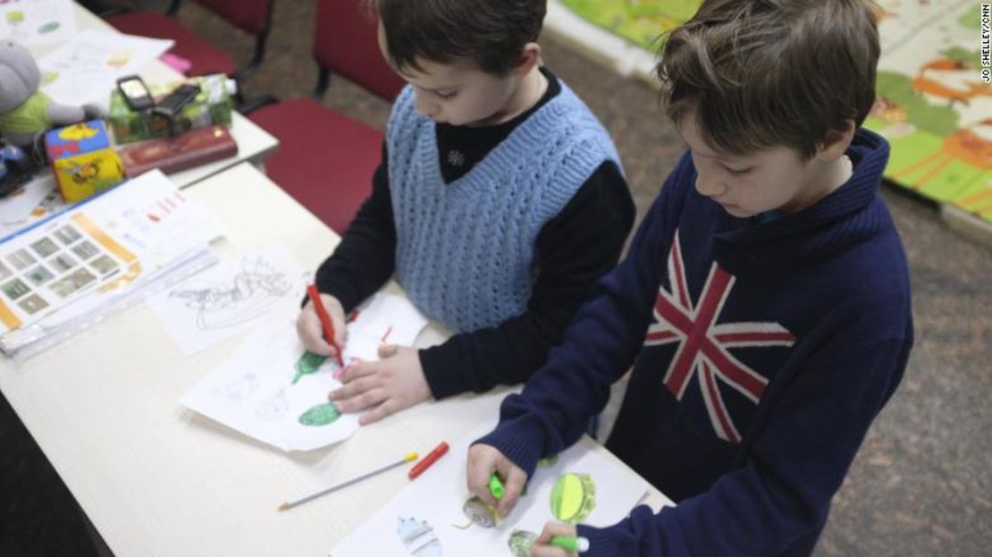 Dos niños colorean en las distintas imágenes, una sombría educación sobre la realidad actual de la vida en su país.