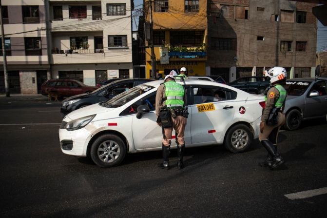 La policía revisa vehículos en un puesto de control en la carretera Panamericana en Lima este martes, en medio del toque de queda que ha provocado inconformidad. El alcalde de Lima rechazó la medida de Castillo y la calificó como "inmoral", pues dijo que deja sin movilidad a 11 millones de personas en Lima y Callao, y esto no les permite "llevar alimento a sus hogares".