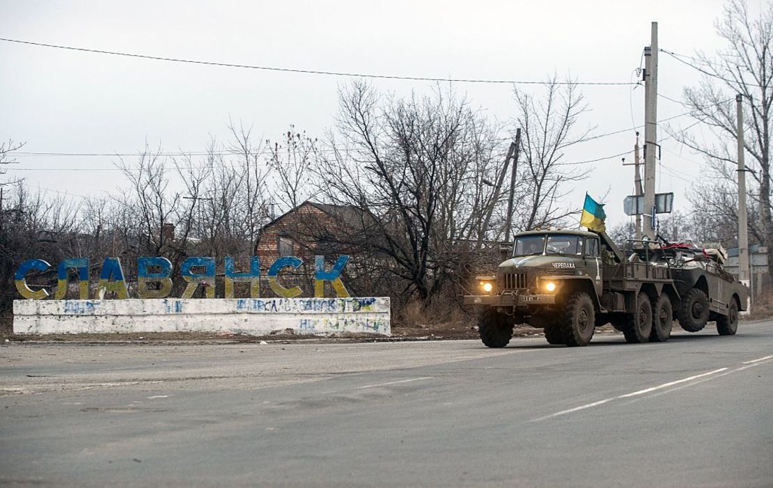 Un camión ucraniano arrastra un vehículo blindado destruido en Sloviansk en febrero de 2015.