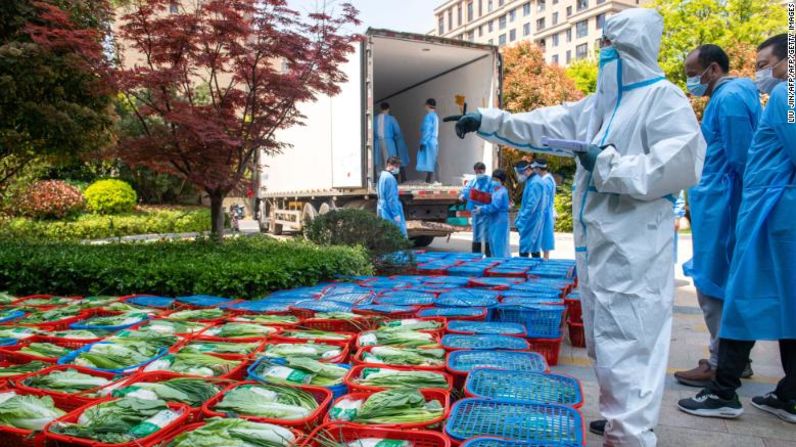 Un voluntario comunitario examina vegetales que serán distribuidos bajo el estricto confinamiento en el distrito Pudong en Shanghai el 12 de abril.