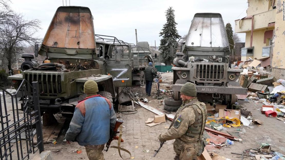 Soldados ucranianos frente a camiones militares rusos dañados en la ciudad de Trostsyanets, a unos 400 kilómetros al este de Kyiv, el 28 de marzo.