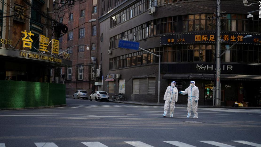 Trabajadores con trajes de protección contra materiales peligrosos vigilan una calle durante el cierre de Shanghái el 16 de abril.