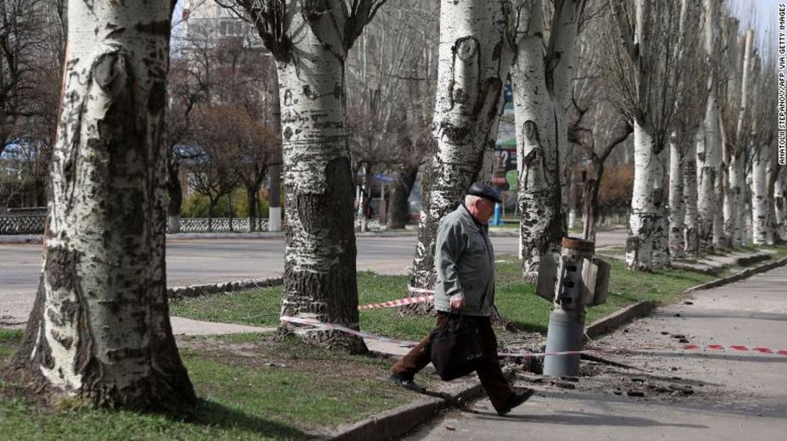 Un anciano camina junto a una sección de cola sin explotar de un cohete de 300 mm incrustado en el suelo en Lisychansk, región de Luhansk, el 11 de abril.