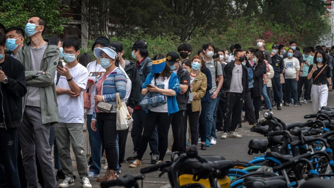 Varias personas hacen fila para someterse a las pruebas de detección de covid-19 en un centro improvisado en el distrito de Chaoyang, en Beijing, este lunes.