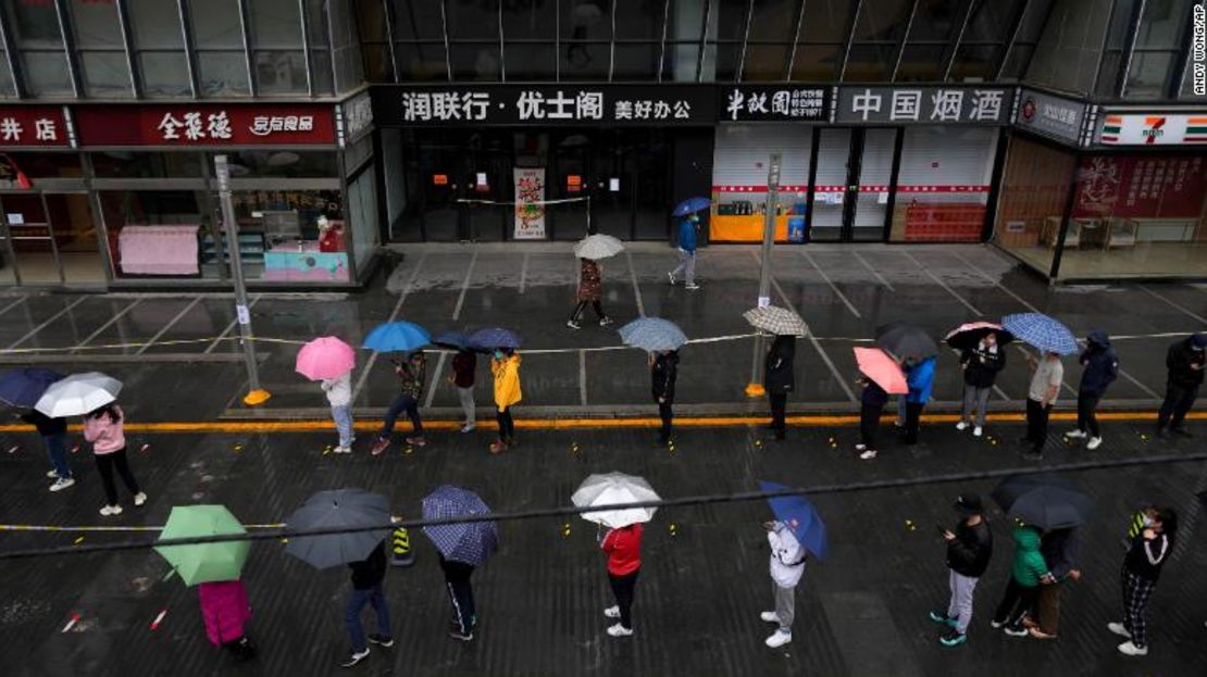 Residentes bajo confinamiento hacen fila bajo la lluvia para las pruebas de covid-19 en Beijing el 27 de abril.