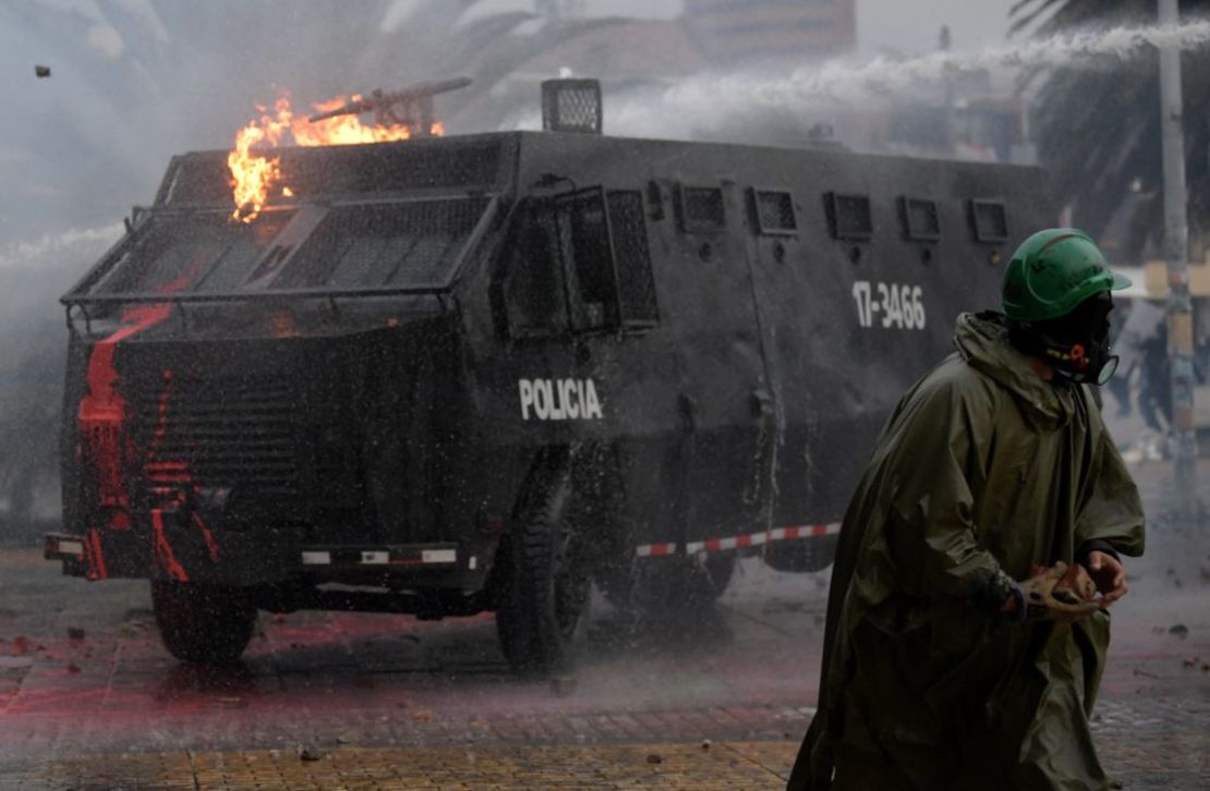 Un manifestante choca con la policía antidisturbios durante una protesta contra el gobierno del presidente colombiano Iván Duque para conmemorar el primer aniversario de un estallido social, frente a la Universidad Nacional en Bogotá, el 28 de abril de 2022.