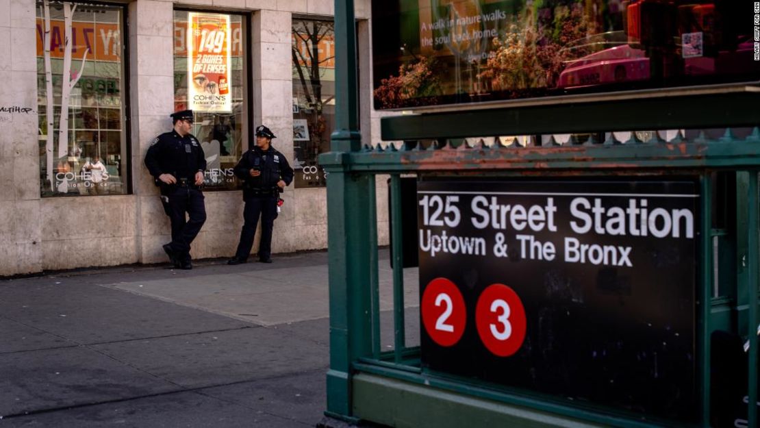 Los agentes de policía se paran afuera de la estación de la calle 125 de Harlem.