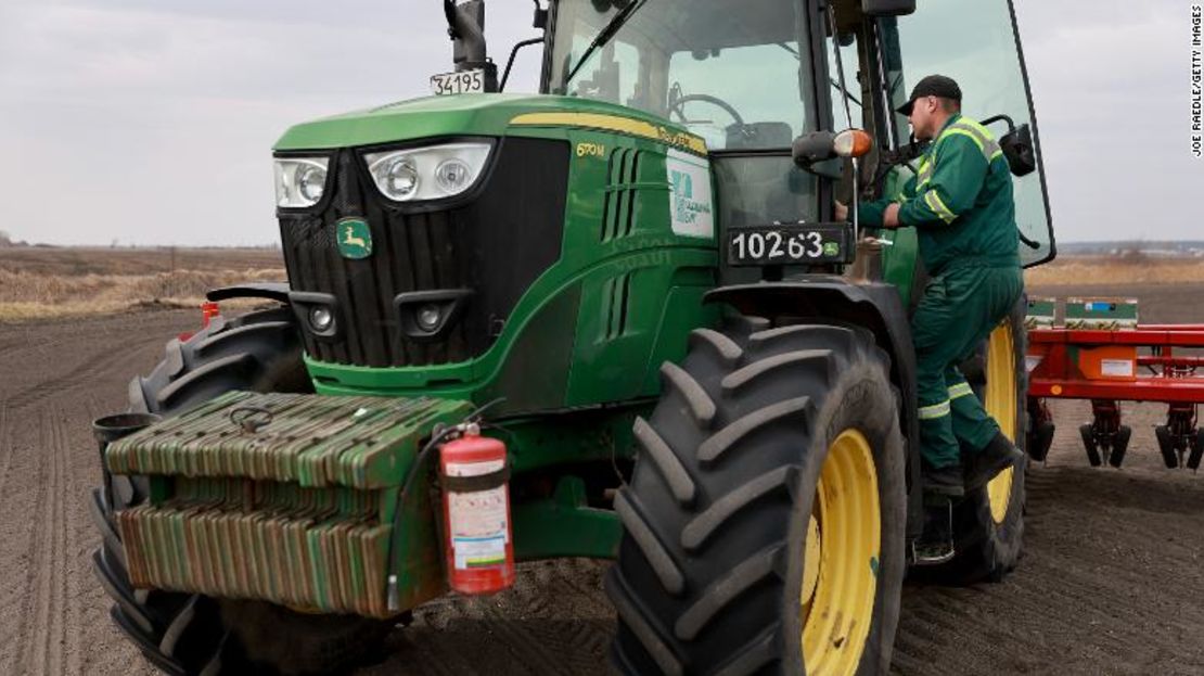 El agricultor ucraniano Morda Vasyl entra en la cabina de un tractor John Deere.