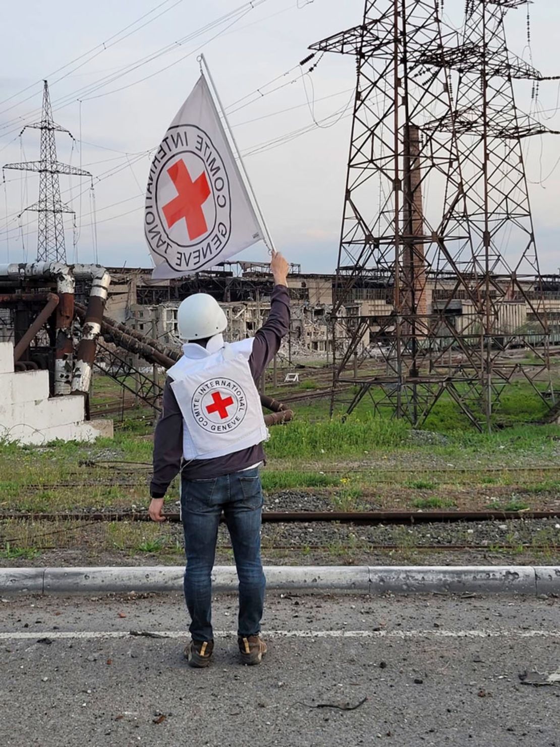 En esta imagen proporcionada por el Comité Internacional de la Cruz Roja, un funcionario de la Cruz Roja ondea una bandera blanca mientras se acerca a la acería Azovstal en Mariúpol, el domingo.