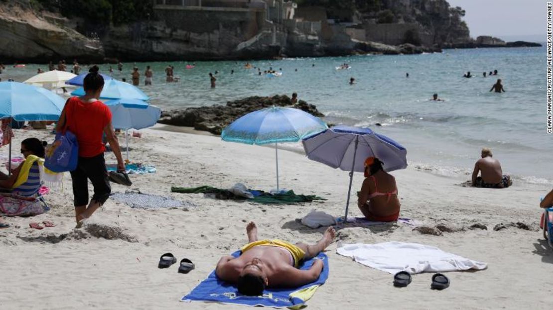 Los dermatólogos afirman que la protección solar debe reaplicarse cada dos horas después de pasar tiempo al aire libre o en el agua. Los turistas se refrescan en Cala Major en Palma de Mallorca, España, el 14 de agosto de 2021.