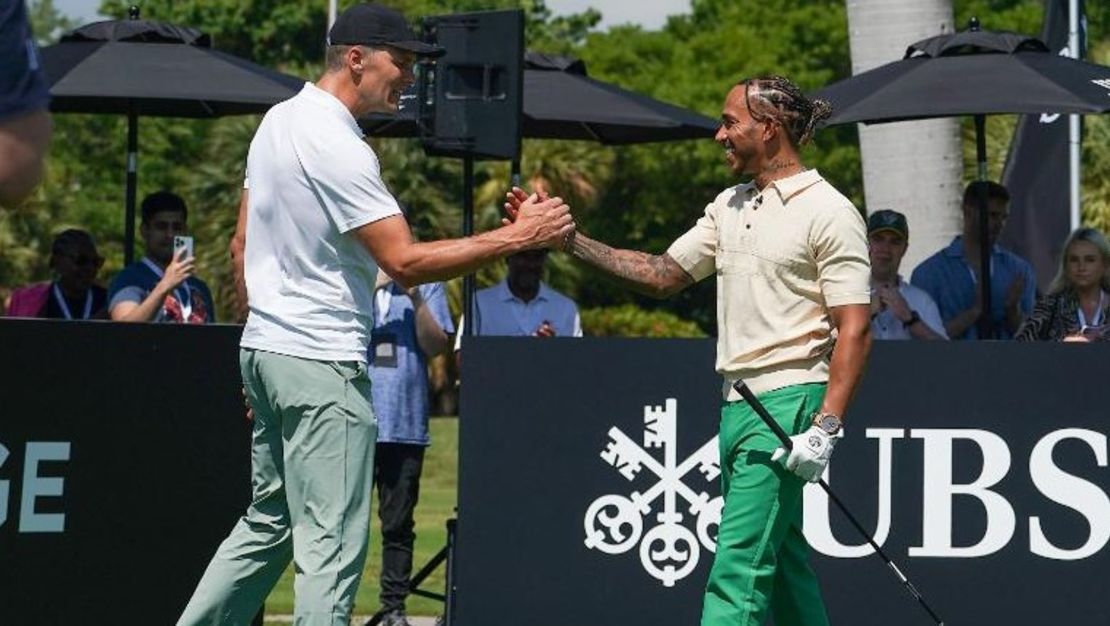 Tom Brady y Lewis Hamilton se dan la mano en el Big Pilot Charity Challenge en el Miami Beach Golf Club, en Miami Beach, Florida, el 4 de mayo de 2022.