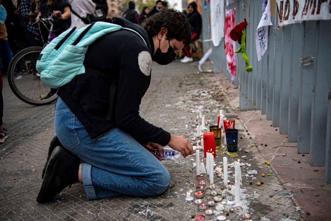 Personas encienden velas afuera del Hospital de Urgencias y Asistencia Pública (HUAP) tras conocer la muerte de la periodista Francisca Sandoval en Santiago, el 12 de mayo de 2022.