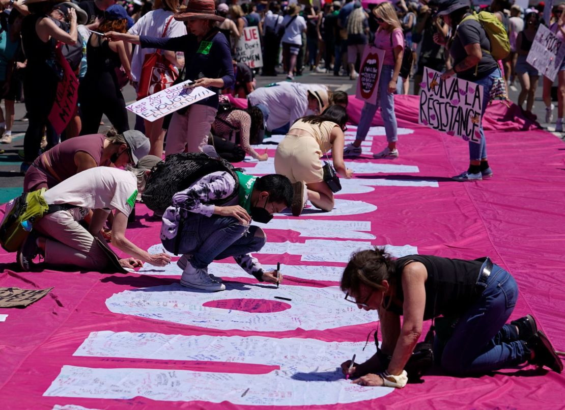 Manifestantes a favor del derecho al aborto escriben en una pancarta gigante durante un mitin en el ayuntamiento de Los Ángeles. Crédito: Damian Dovarganes/AP