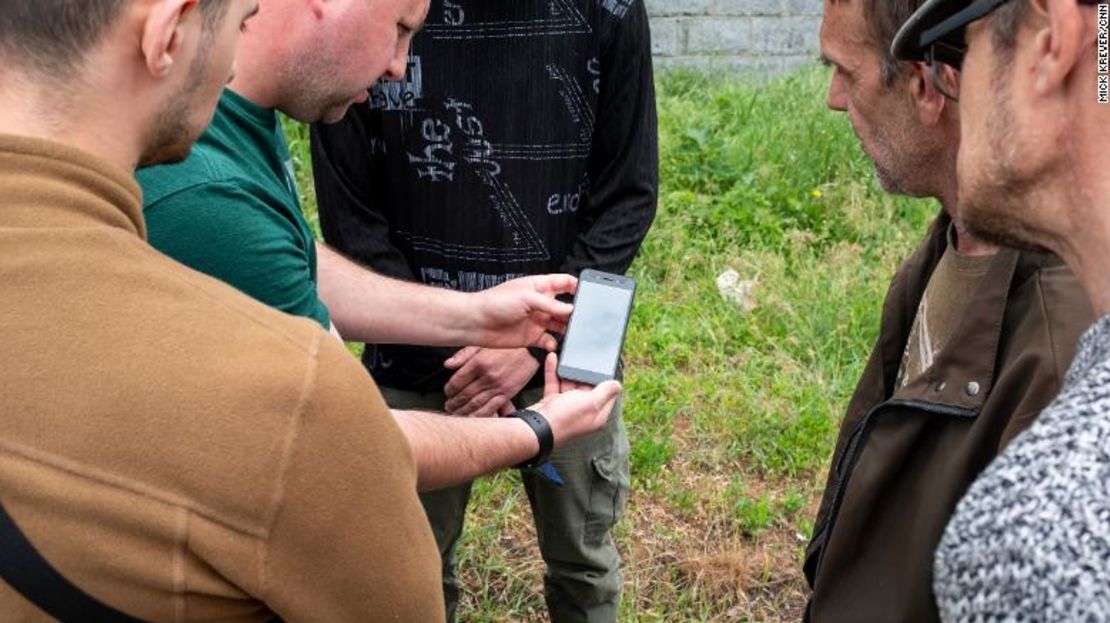 Agentes del servicio de seguridad de Ucrania registran el teléfono de un sospechoso que se cree que ha enviado información a las fuerzas rusas.