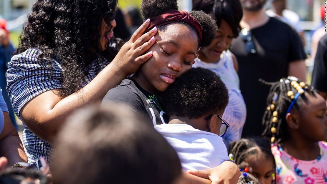 La gente rodea a Deazjah Roseboro, de 12 años, mientras consuela a su primo de 8 años, Jerney Moss.